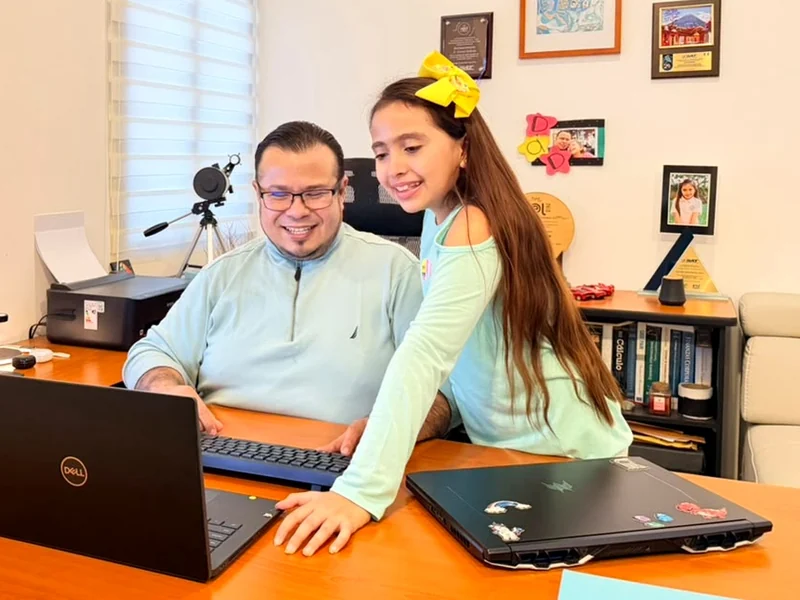 David Beltrán y su hija Denisse trabajando juntos frente a la computadora